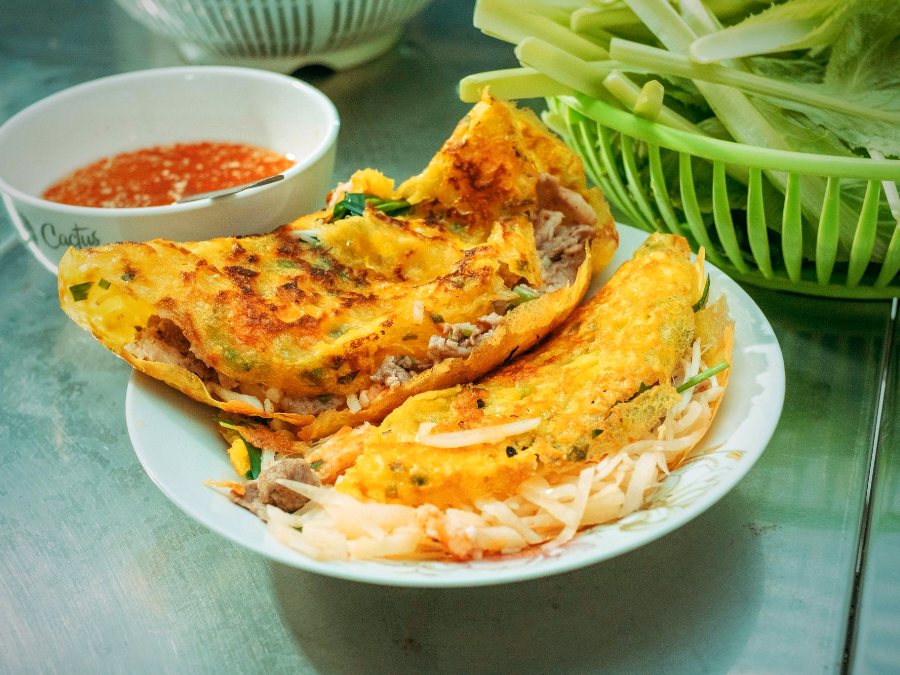 Bánh xèo vàng giòn với rau sống và chén nước chấm